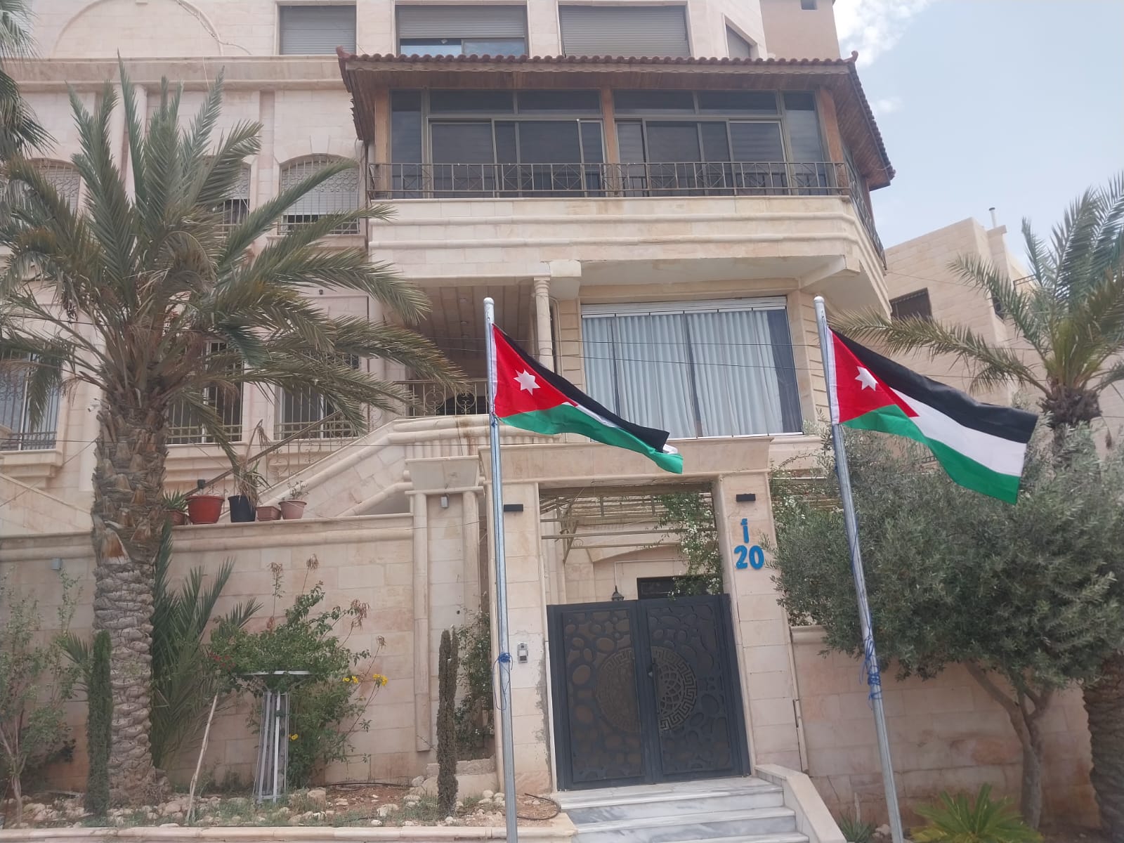 رئيس بلدية الزرقاء الكبرى يرفع سارتي العلم الأردني أمام منزله