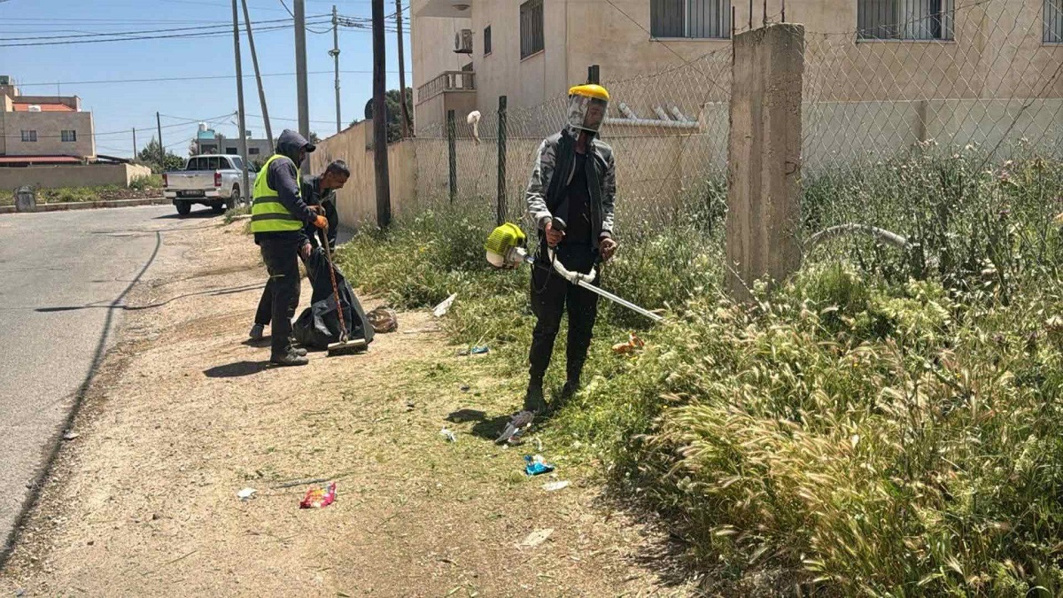 بلدية غرب إربد تواصل إزالة الأعشاب الجافة في مختلف المناطق